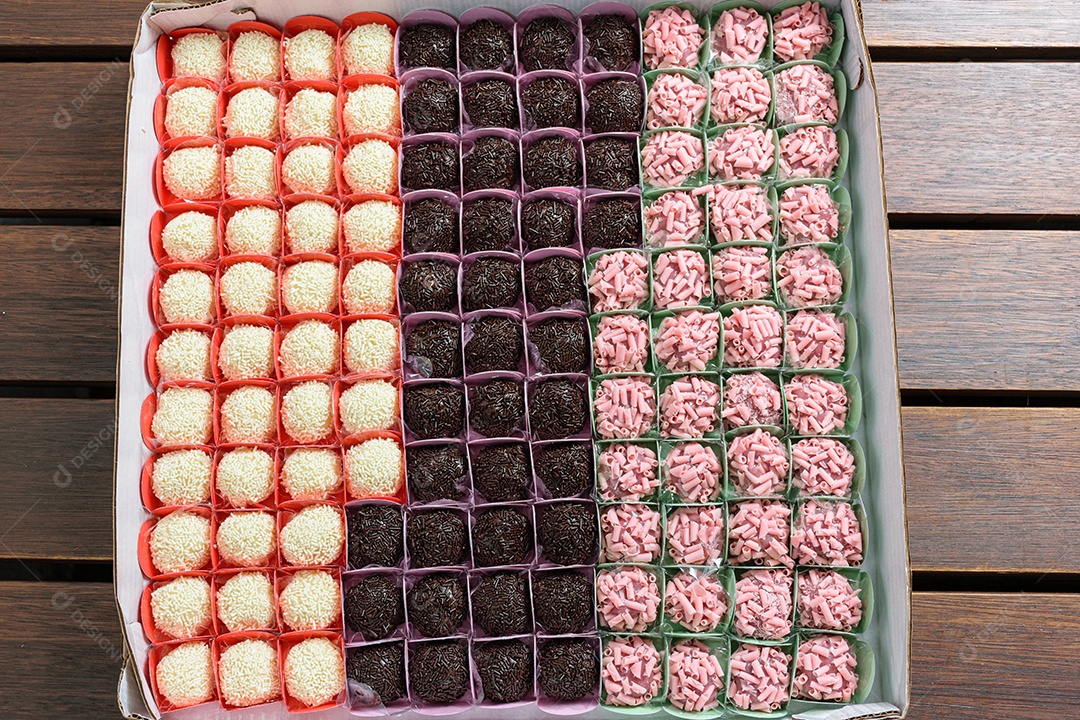 Vários tipos de brigadeiros organizados em fileiras. Brigadeiros de chocolate