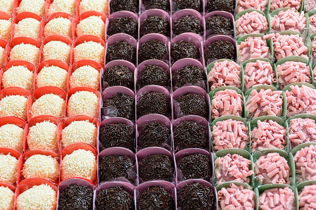 Vários tipos de brigadeiros organizados em fileiras. Brigadeiros de chocolate