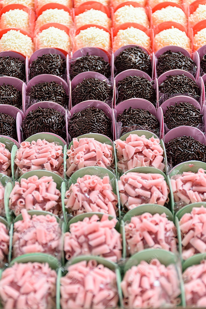 Vários tipos de brigadeiros organizados em fileiras. Brigadeiros de chocolate