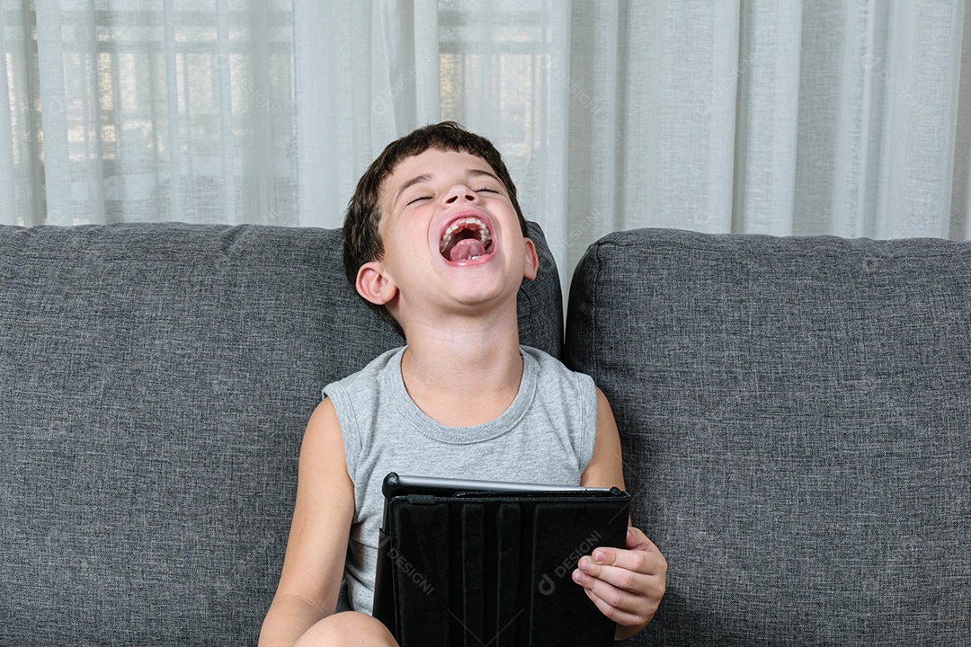 Criança de 7 anos, apontando para o tablet se divertindo