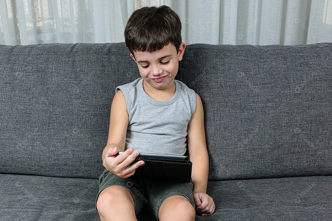 Criança de 7 anos, apontando para o tablet se divertindo