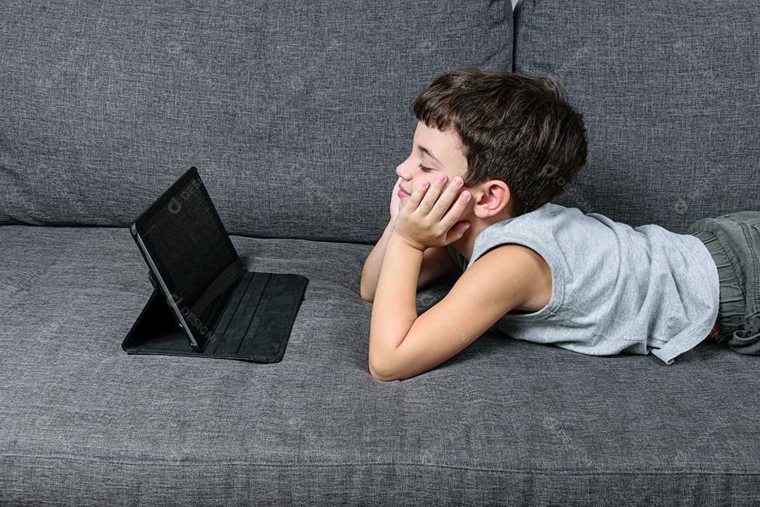 Criança de 7 anos, apontando para o tablet se divertindo