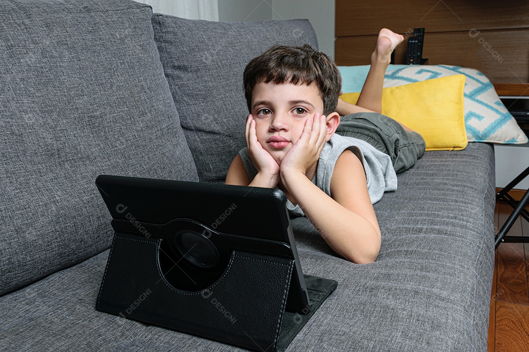 Criança de 7 anos, apontando para o tablet se divertindo