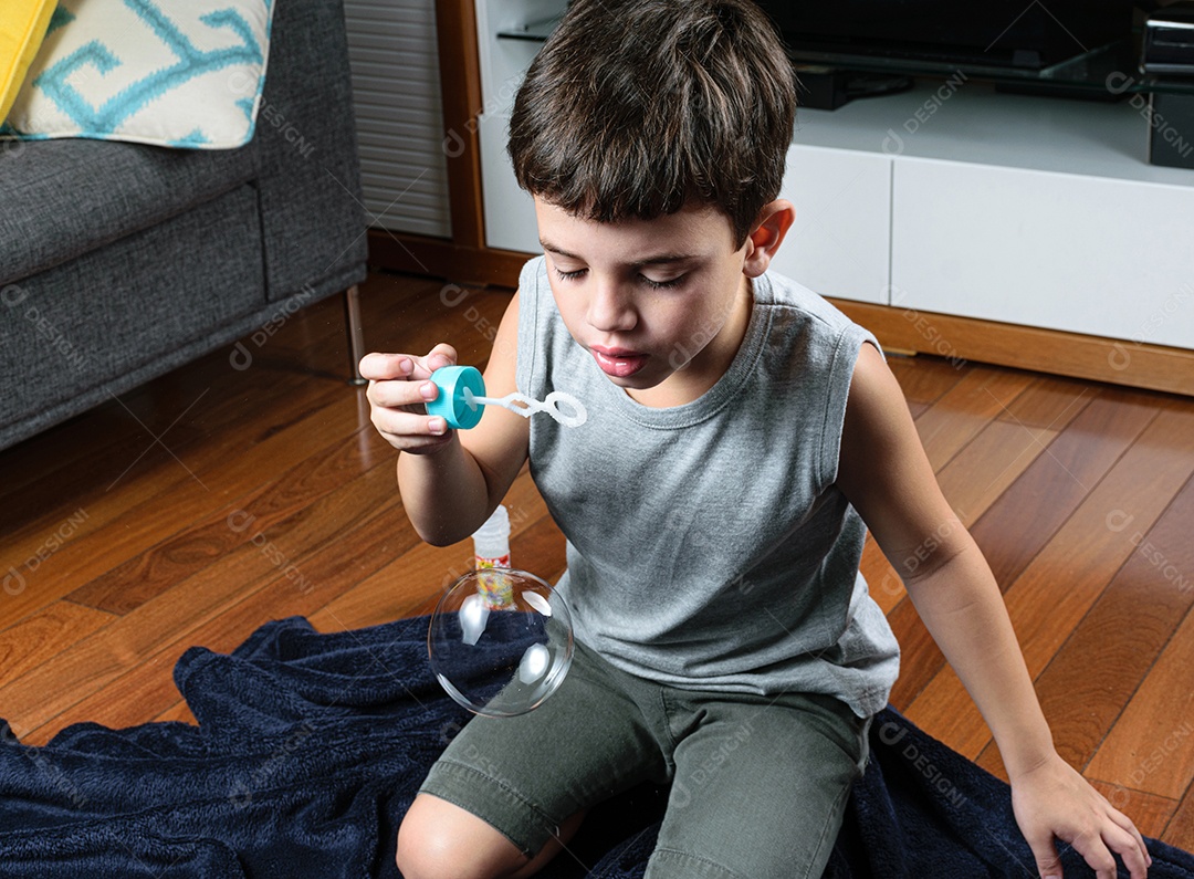 Criança de 7 anos, surpresa, observando uma bolha de sabão.