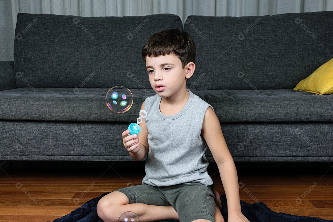 Criança de 7 anos, surpresa, observando uma bolha de sabão.