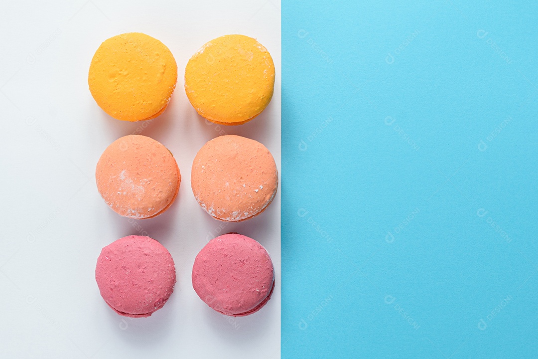 Porção de biscoitos coloridos sobre um fundo branco e azul.