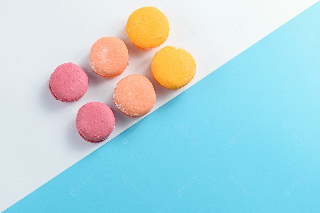 Porção de biscoitos coloridos sobre um fundo branco e azul.