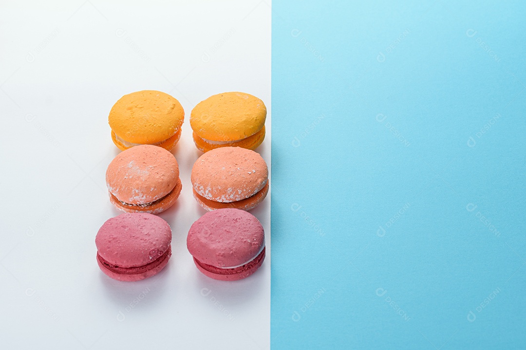 Porção de biscoitos coloridos sobre um fundo branco e azul.