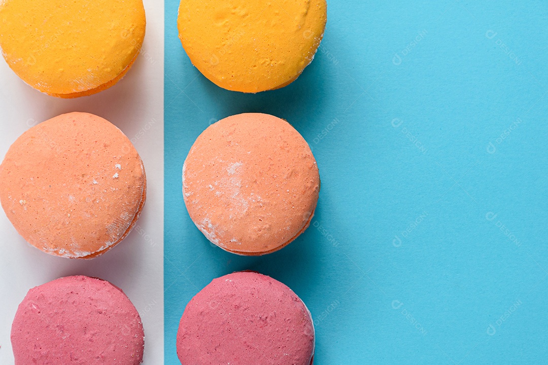 Porção de biscoitos coloridos sobre um fundo branco e azul.