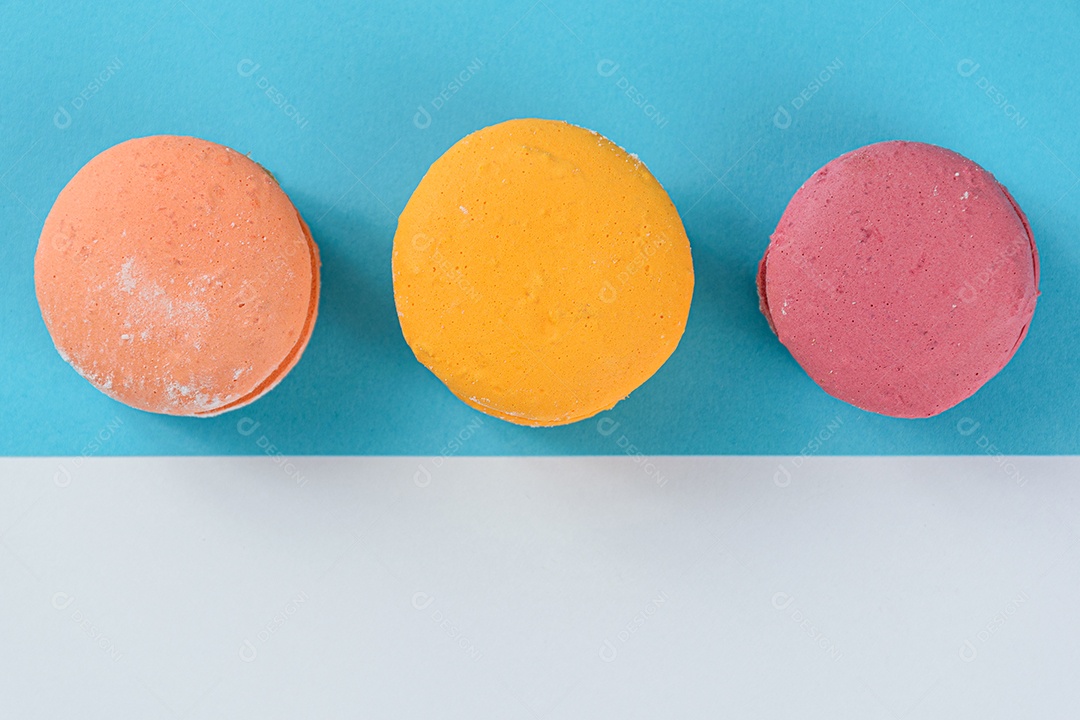 Porção de biscoitos coloridos sobre um fundo branco e azul.