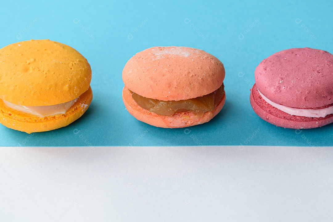 Porção de biscoitos coloridos sobre um fundo branco e azul.