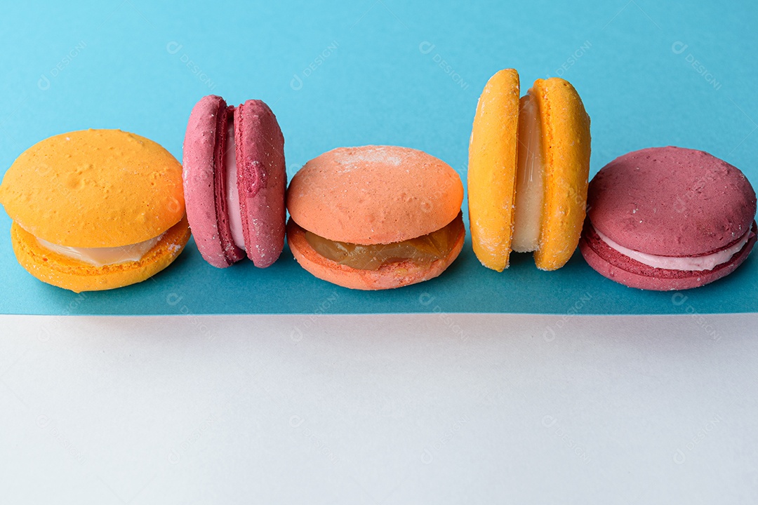 Porção de biscoitos coloridos sobre um fundo branco e azul.