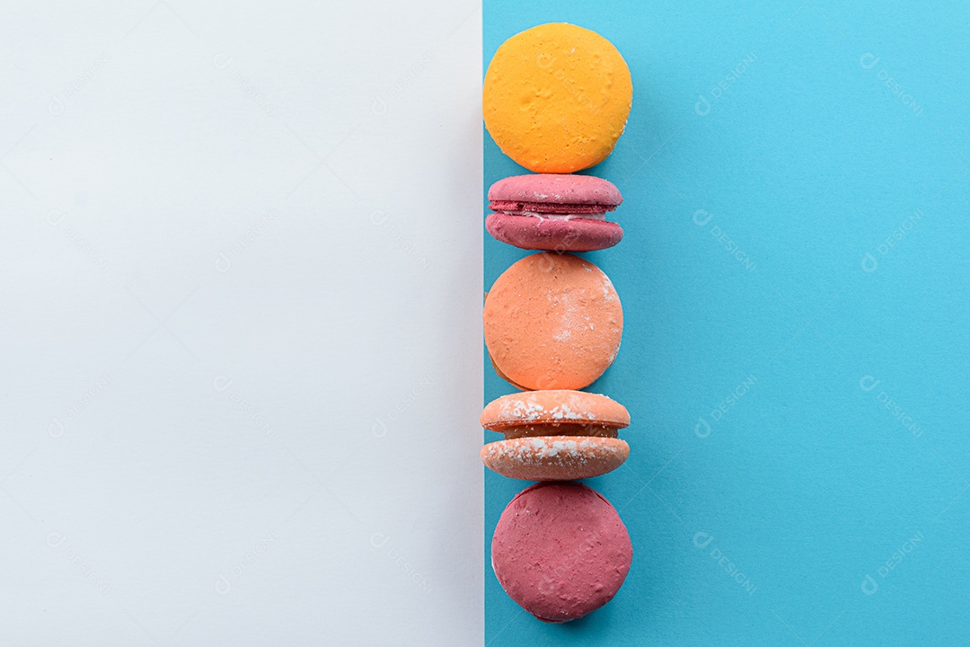 Porção de biscoitos coloridos sobre um fundo branco e azul.