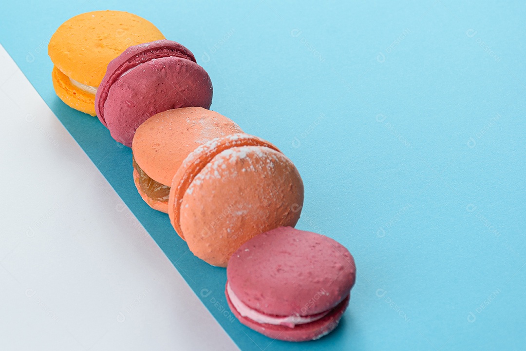 Porção de biscoitos coloridos sobre um fundo branco e azul.