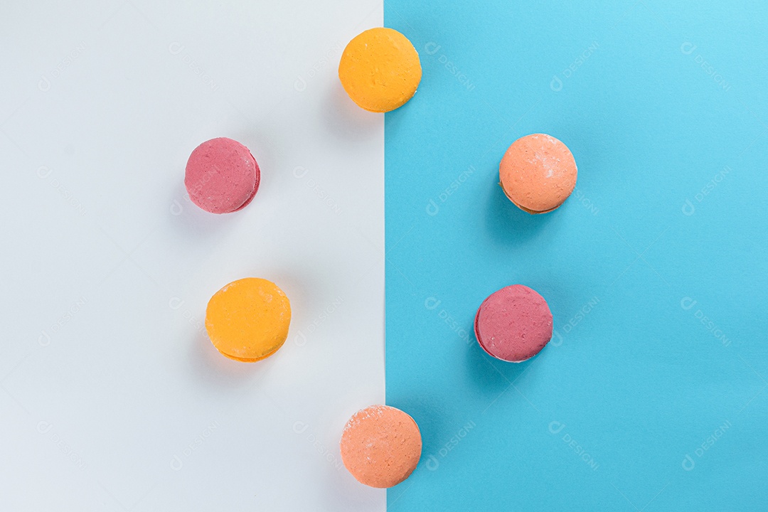 Porção de biscoitos coloridos sobre um fundo branco e azul.