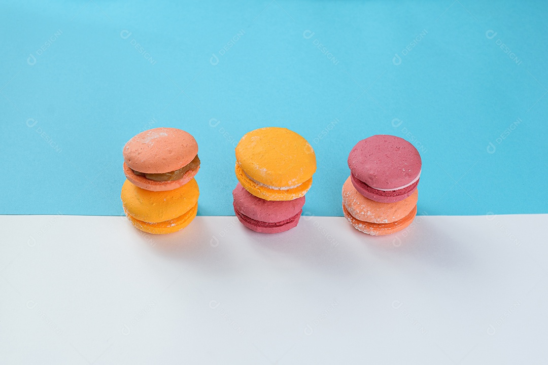 Porção de biscoitos coloridos sobre um fundo branco e azul.