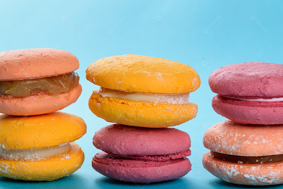 Porção de biscoitos coloridos sobre um fundo azul.