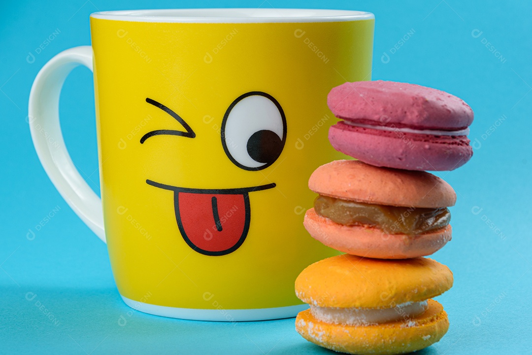 Olho da caneca amarela, observando macarons empilhados coloridos