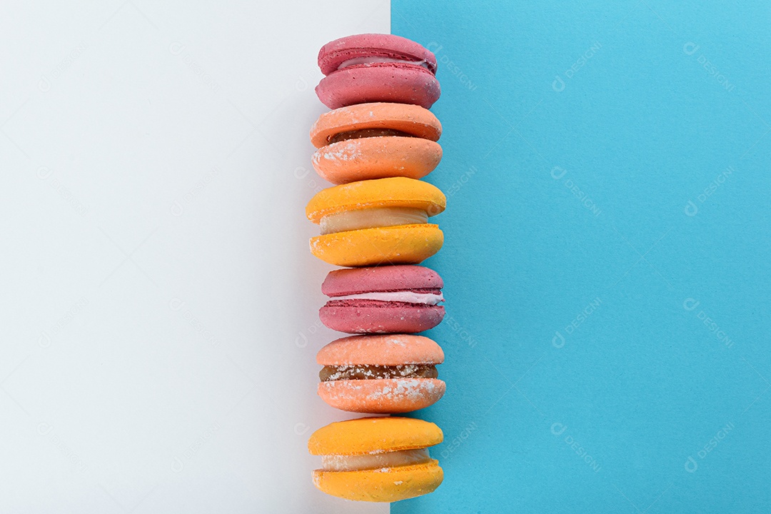 Porção de biscoitos coloridos sobre um fundo branco e azul.