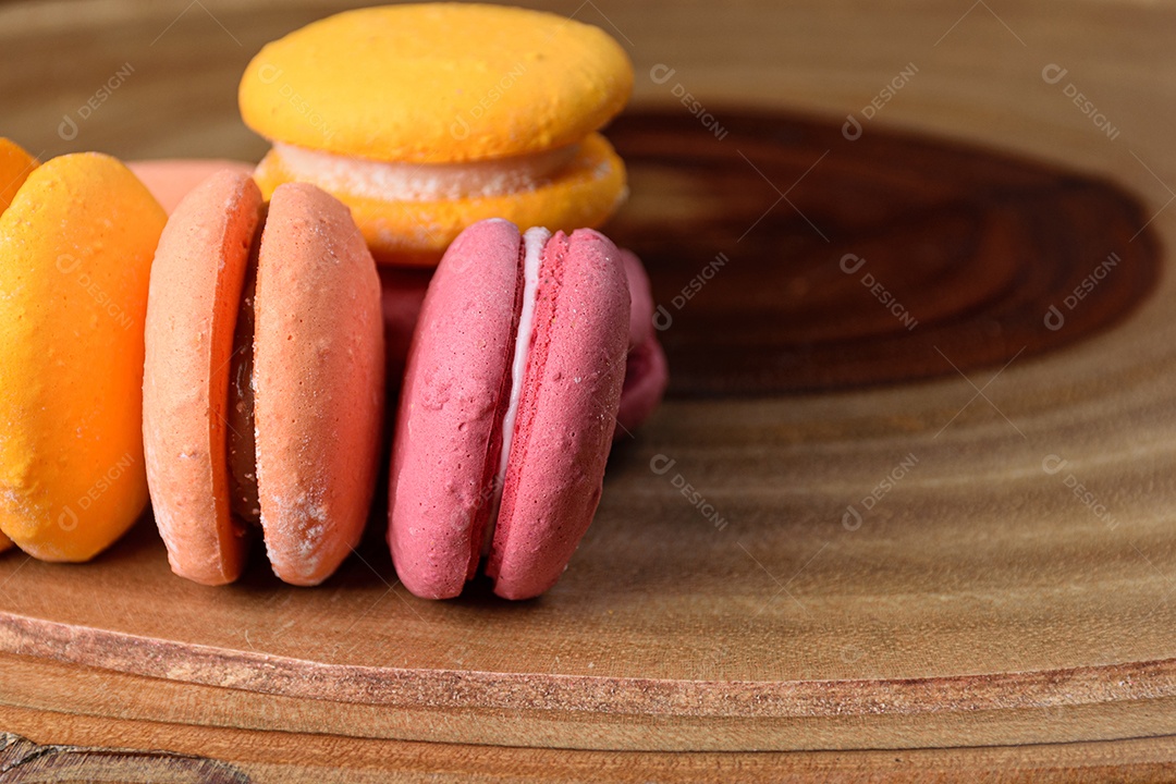 Biscoitos coloridos em uma placa de madeira.