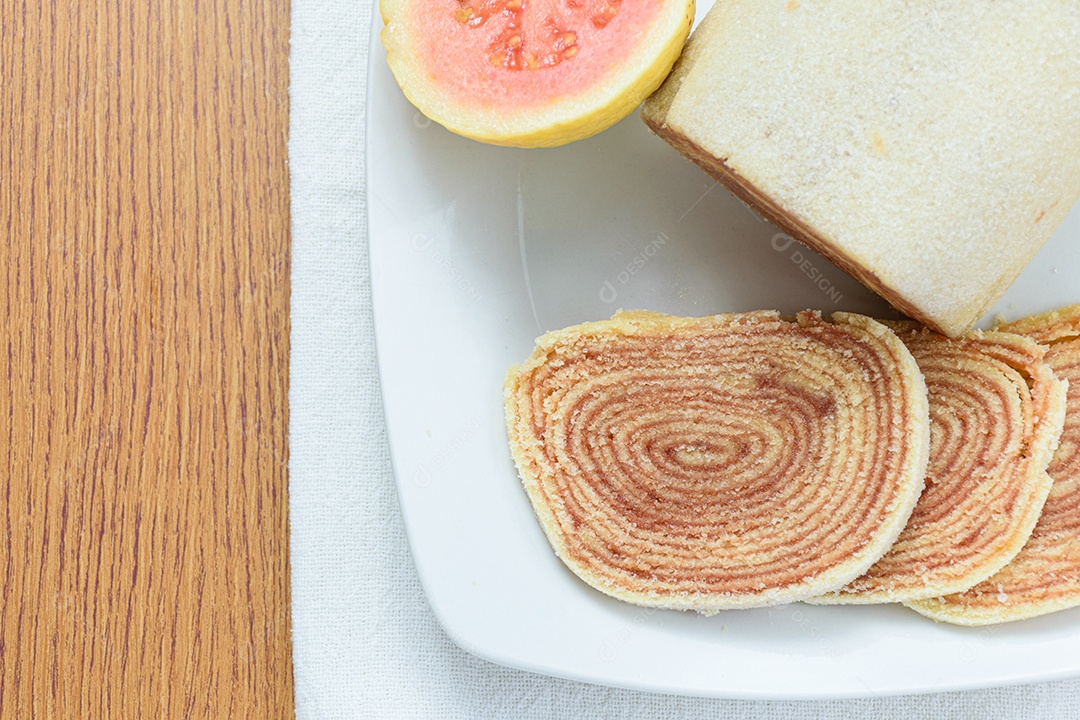 Fatias de bolo de rolo no centro de uma tábua de madeira.