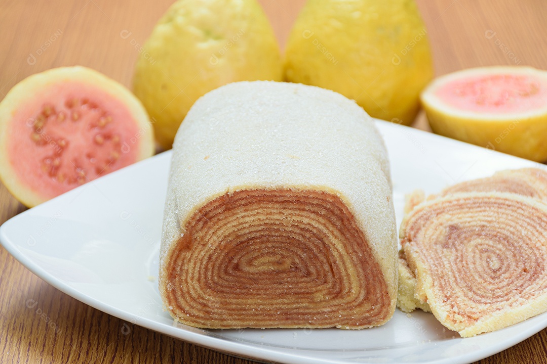Fatias de bolo de rolo no centro de uma tábua de madeira.