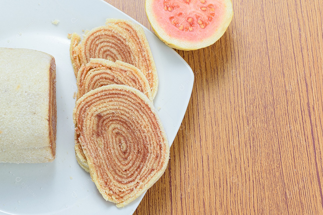 Fatias de bolo de rolo no centro de uma tábua de madeira.