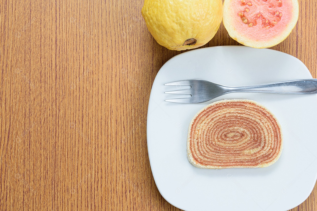 Fatias de bolo de rolo no centro de uma tábua de madeira.