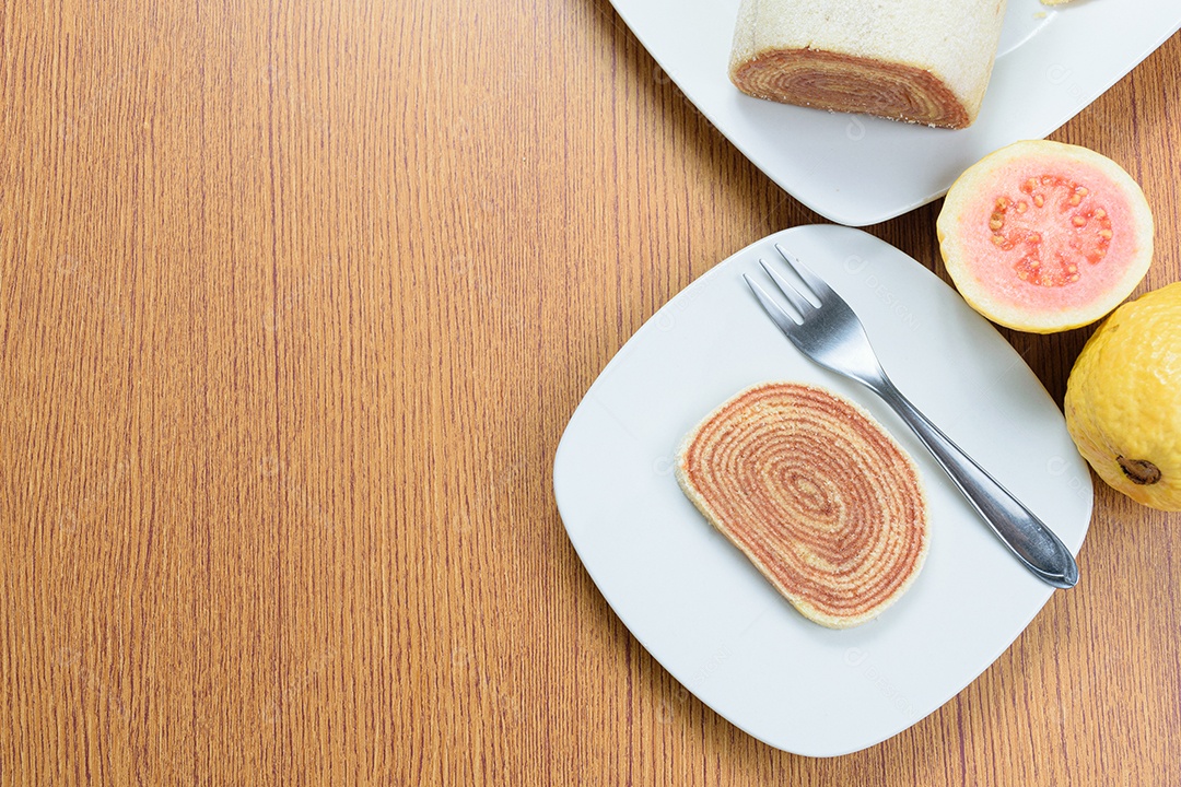 Fatias de bolo de rolo no centro de uma tábua de madeira.