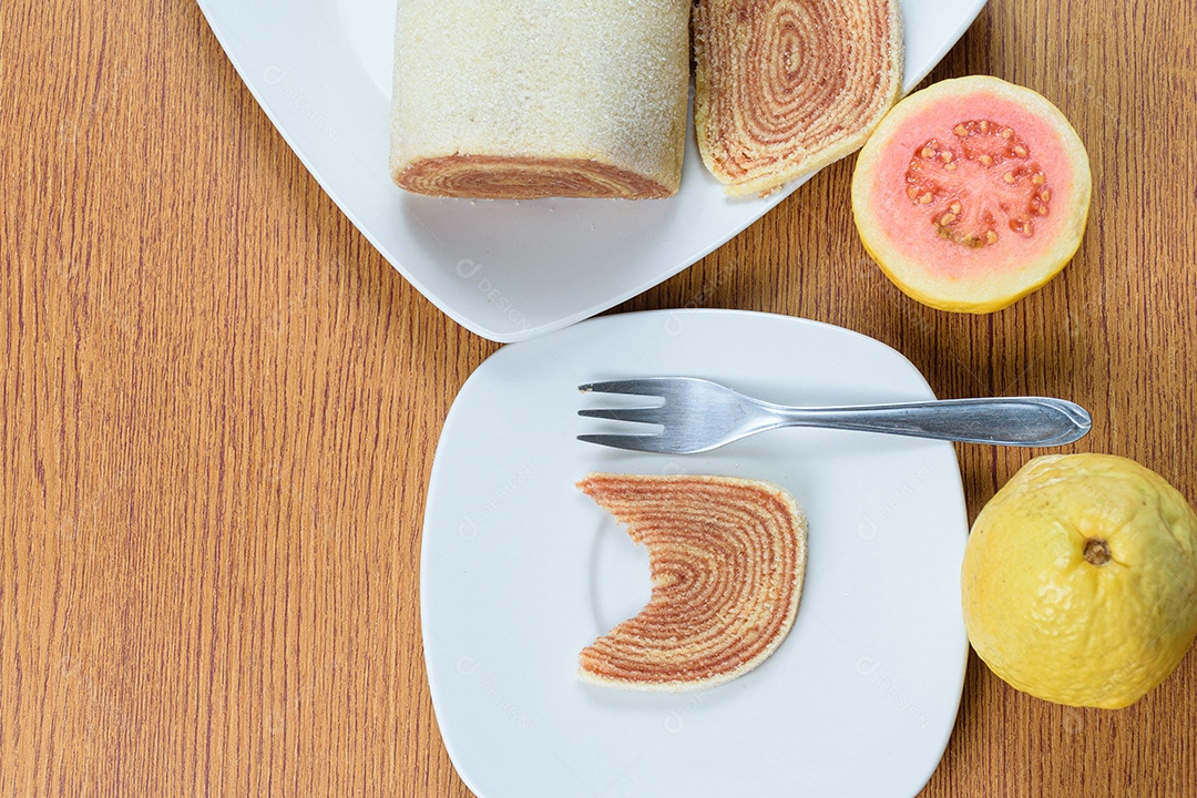 Fatias de bolo de rolo no centro de uma tábua de madeira.