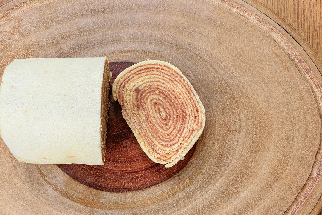 Fatias de bolo de rolo no centro de uma tábua de madeira.