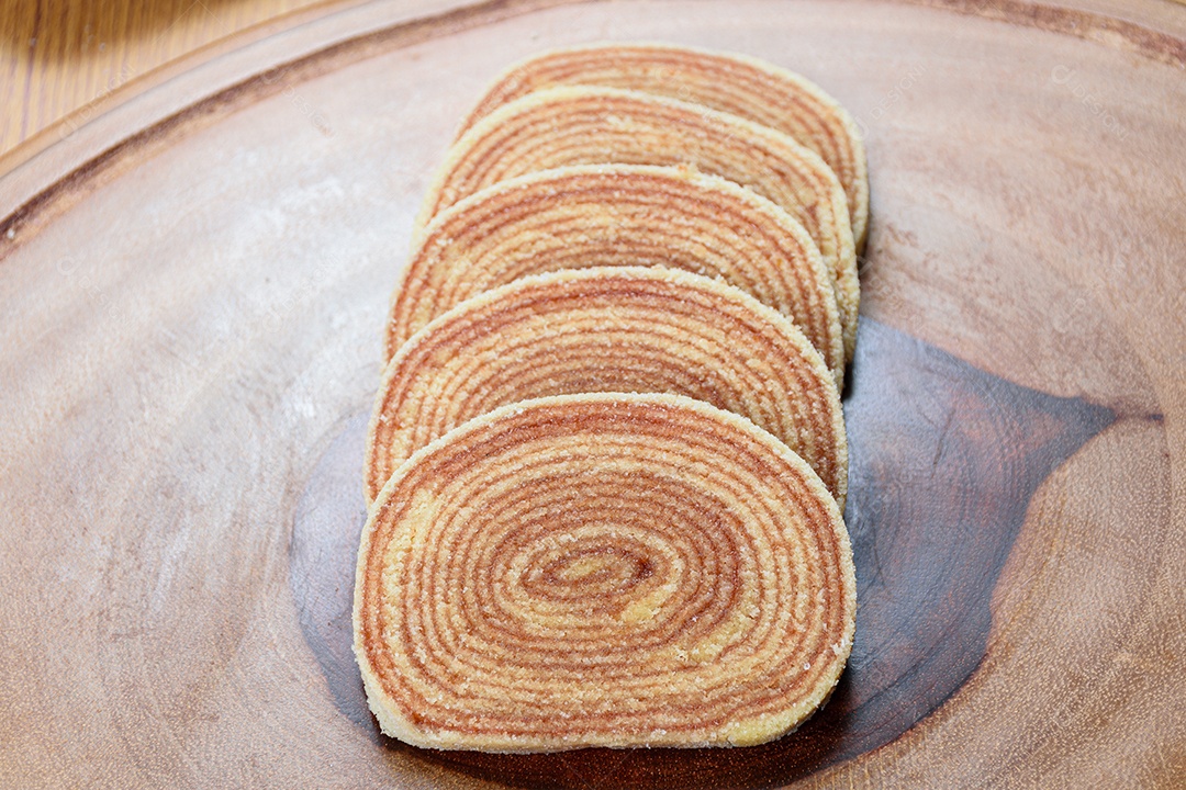 Fatias de bolo de rolo no centro de uma tábua de madeira.