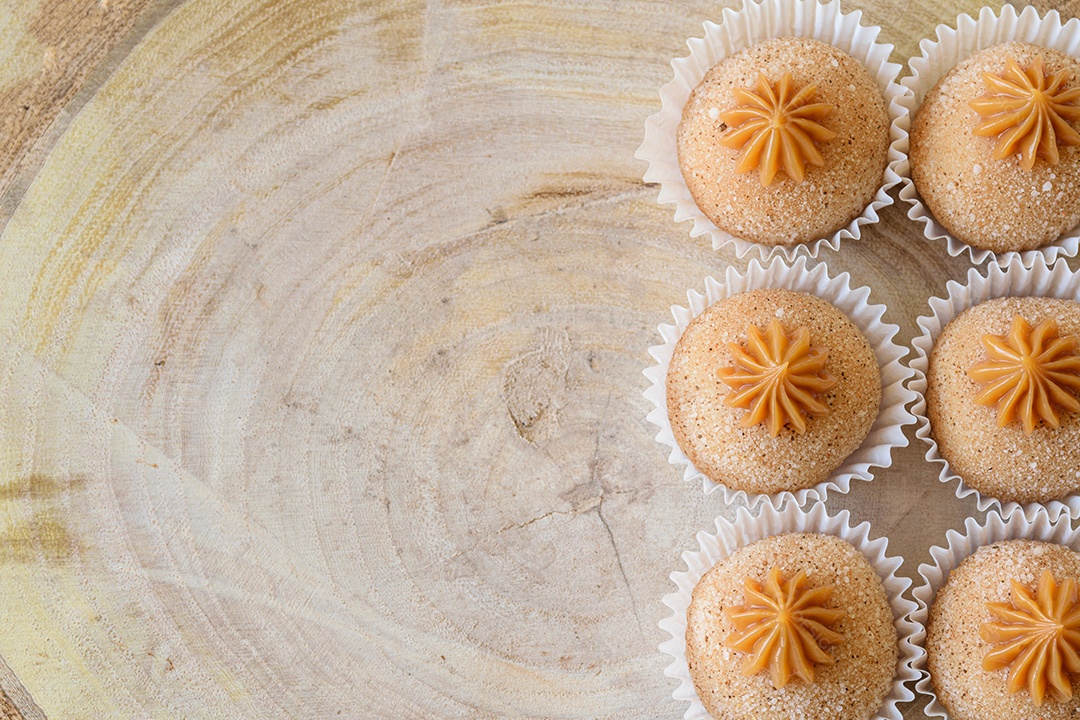 Brigadeiros de churros sobre tábua de pau-brasil.