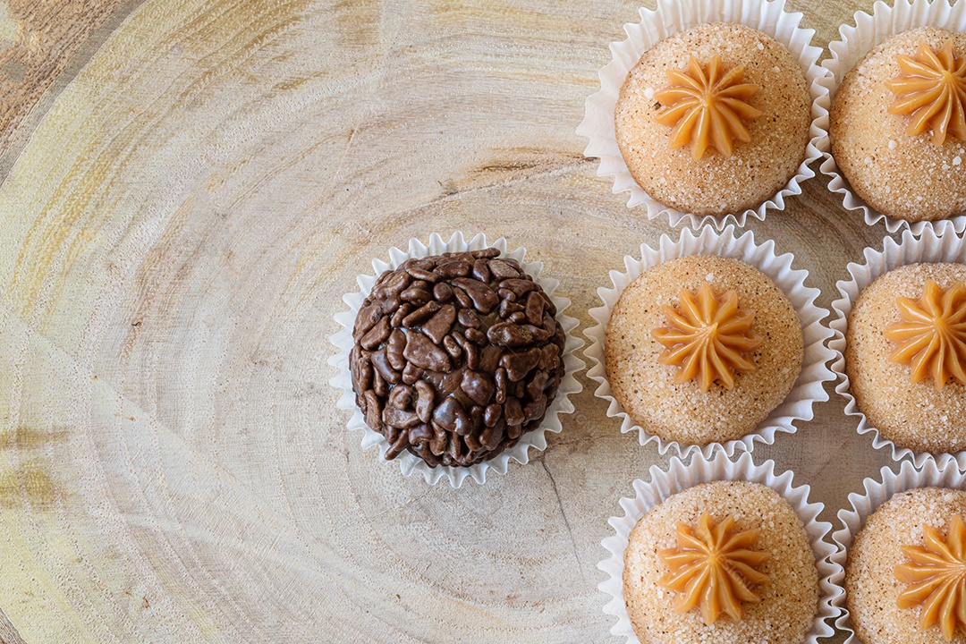 Brigadeiro de chocolate granulado acompanhado de brigadeiros de churros.