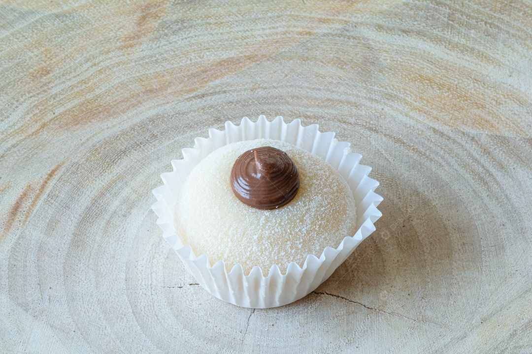 Detalhe de um brigadeiro branco com creme de chocolate brigadeiro