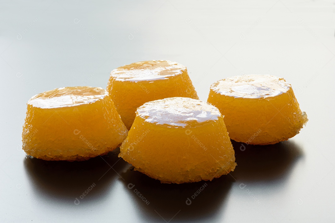 Vários quindins sobre fundo preto fosco. Doce tradicional brasileiro.