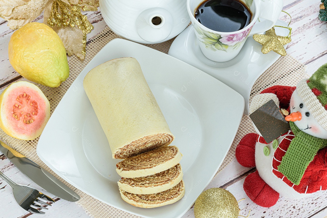 Bolo de rolo ao lado de uma decoração de Natal. Doce tradicional