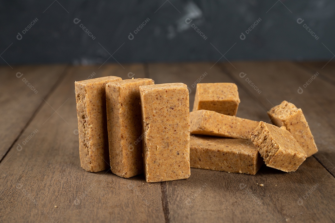 Pilha de doce de amendoim brasileiro chamado paçoca em uma mesa de madeira.