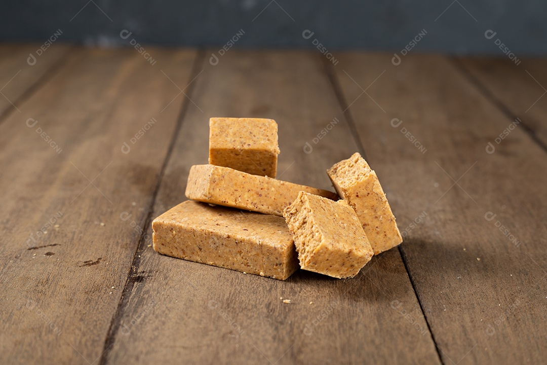 Pilha de doce de amendoim brasileiro chamado paçoca em uma mesa de madeira.