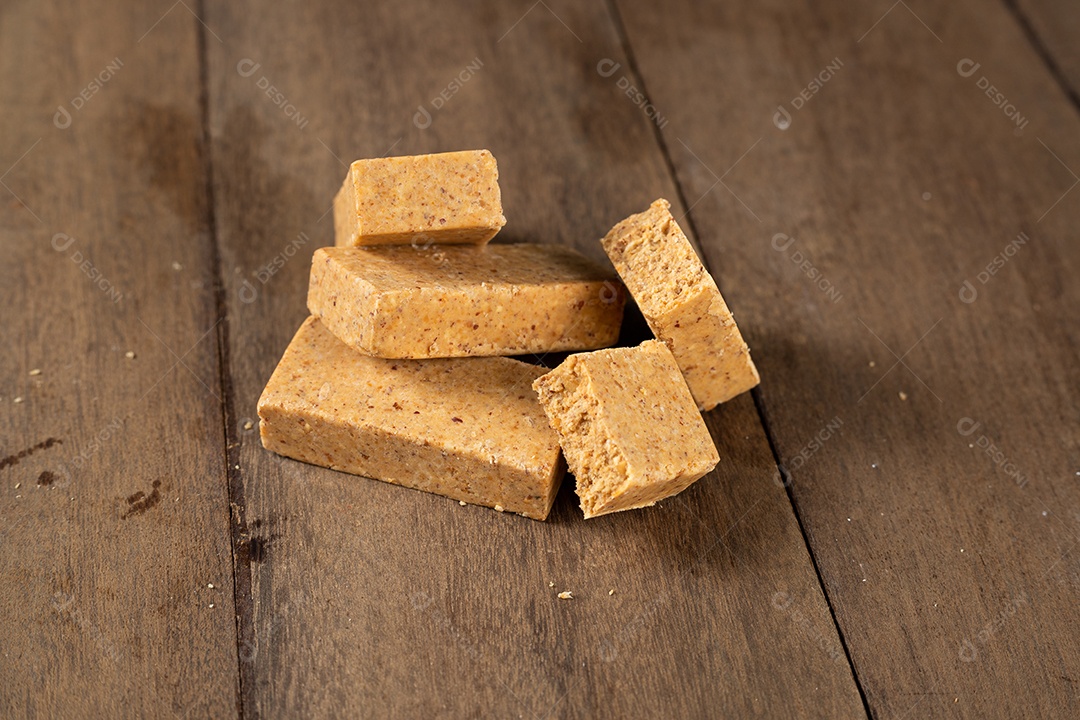 Pilha de doce de amendoim brasileiro chamado paçoca em uma mesa de madeira.