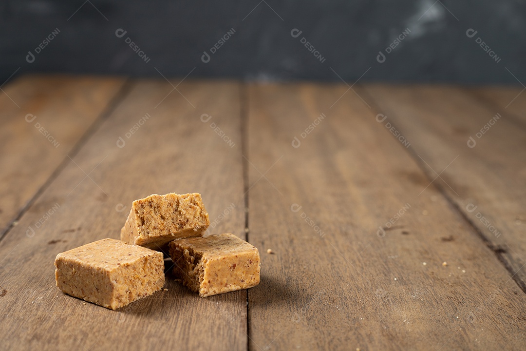 Pile of Brazilian peanut candy called paçoca on a wooden table.