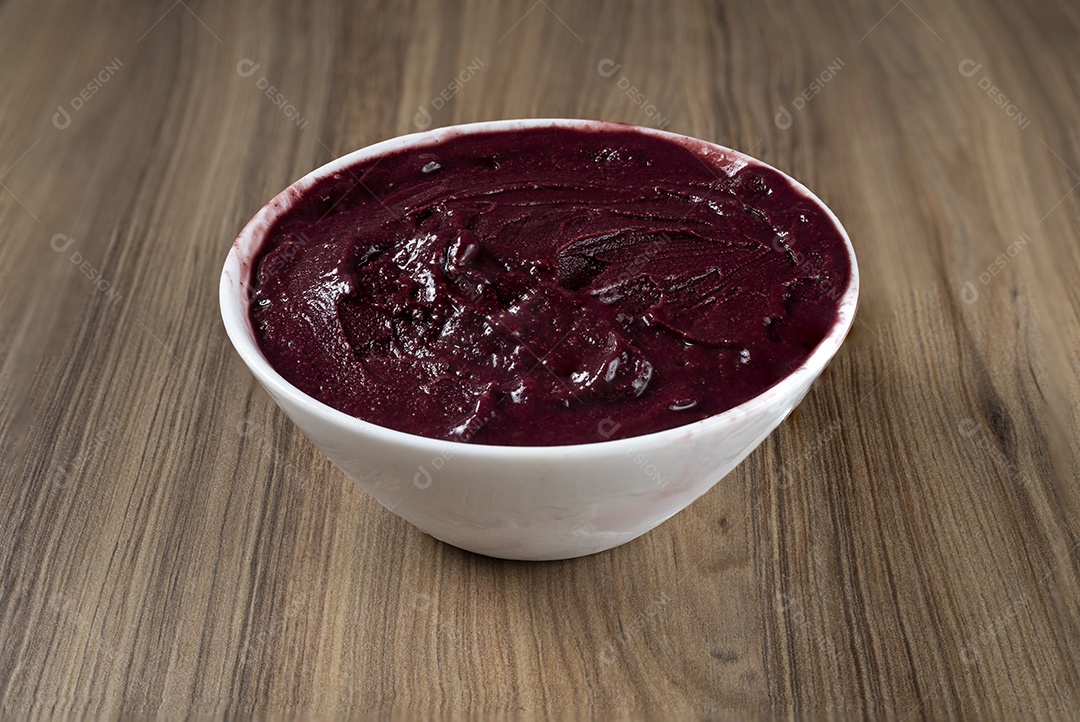 Tigela branca de açaí brasileiro congelado com paçoca, morango e banana.
