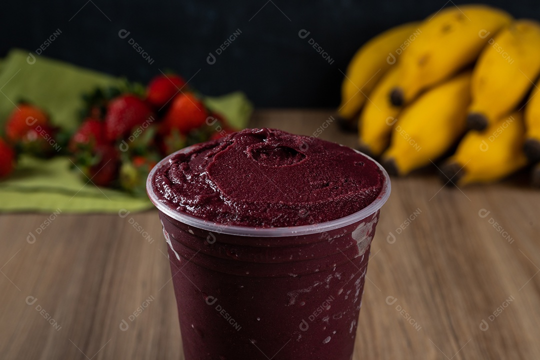 Tigela branca de açaí brasileiro congelado com paçoca, morango e banana.