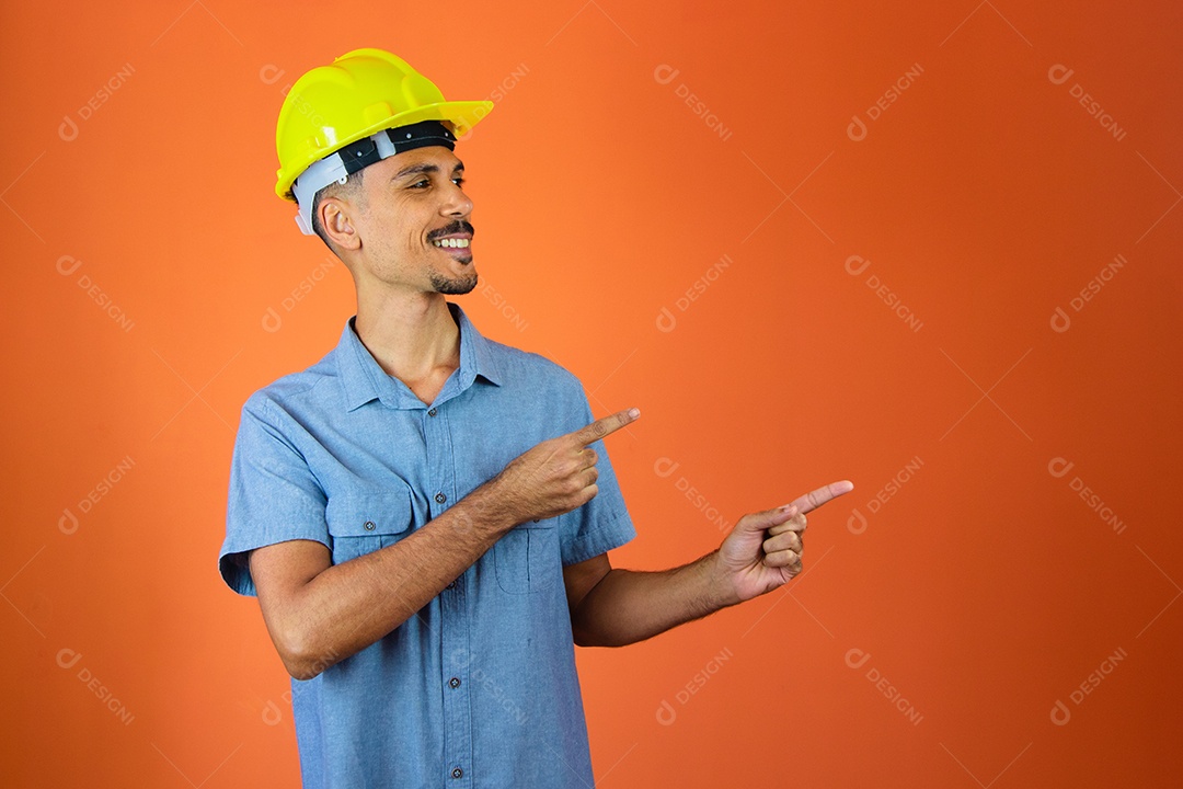 Black man in safety helmet and blue shirt isolated on orange.