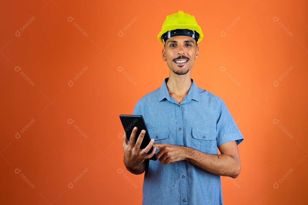 Engenheiro segurando Mobile - homem negro no capacete de segurança e camisa