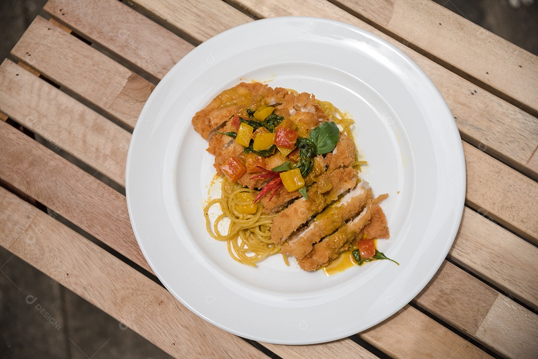 Prato de macarronada sobre prato branco mesa de um restaurante janta