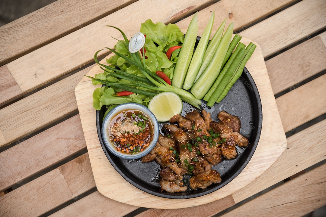 Prato sobre uma mesa de madeira legumes limão carne molho