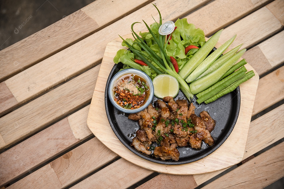 Prato sobre uma mesa de madeira legumes limão carne molho