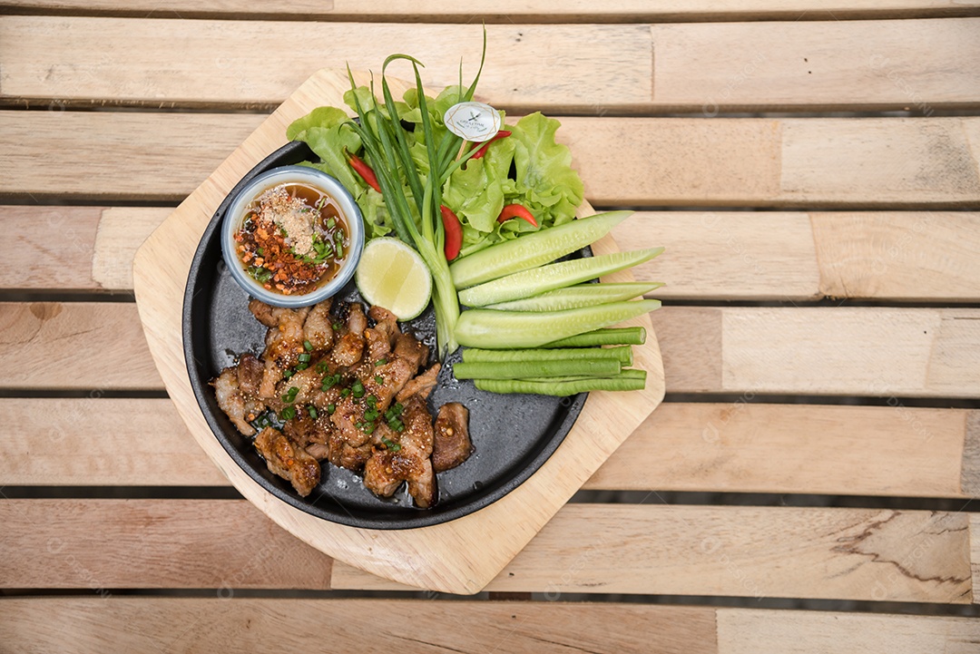 Prato sobre uma mesa de madeira legumes limão carne molho