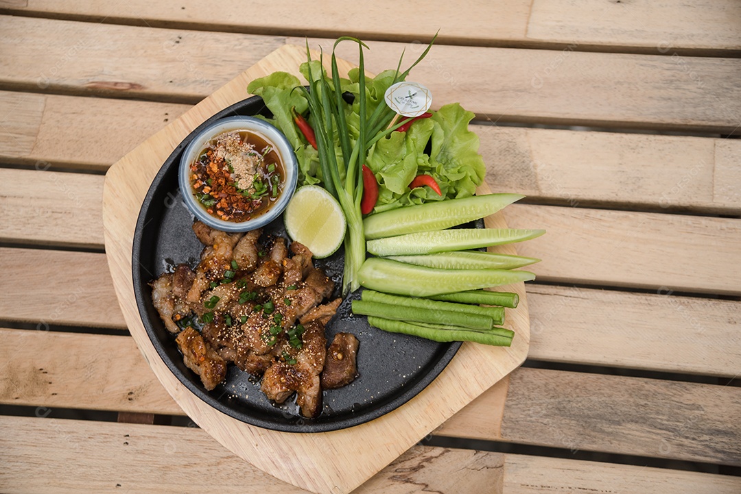 Prato sobre uma mesa de madeira legumes limão carne molho